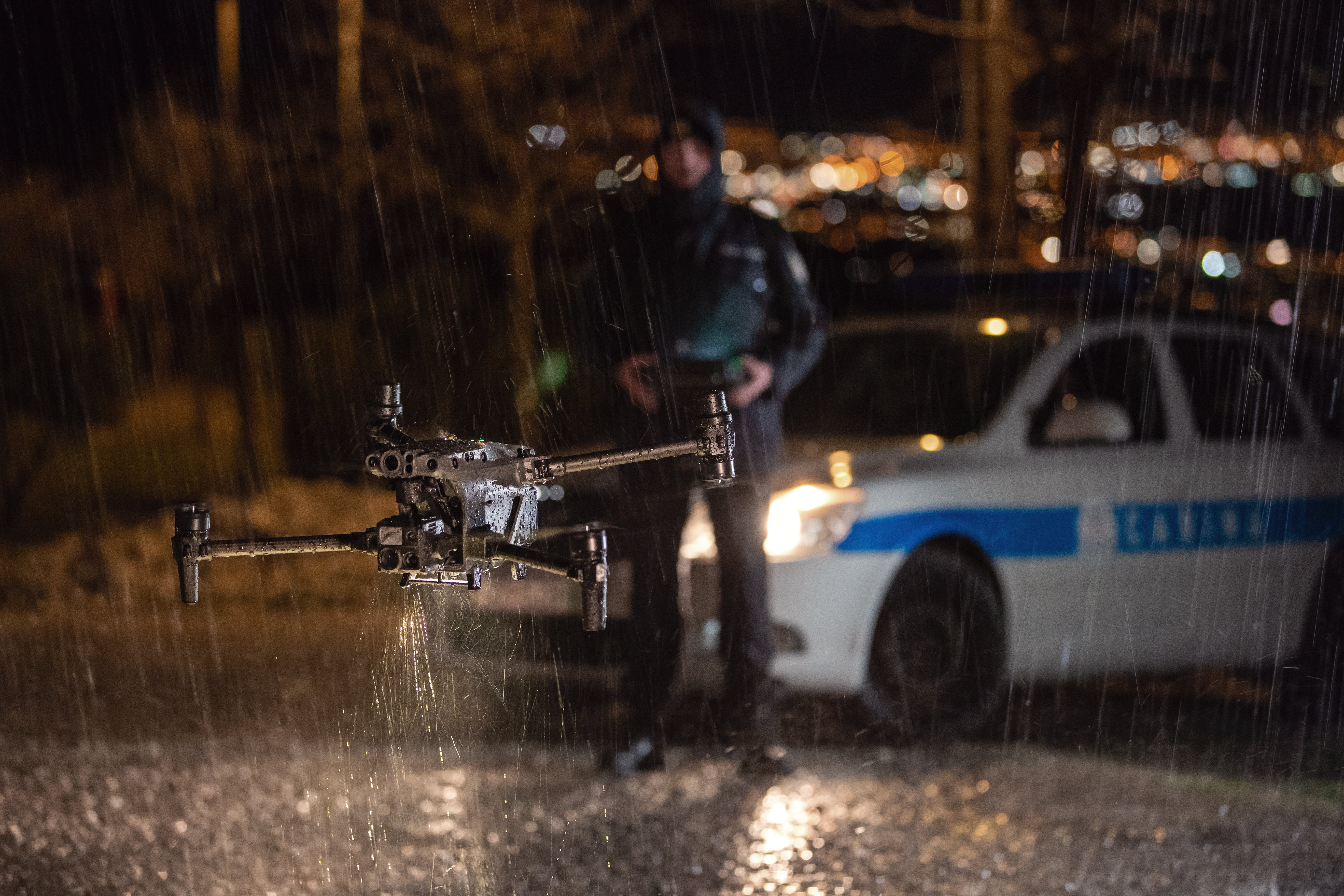 Police Officer Flying Drone at Night in the Rain